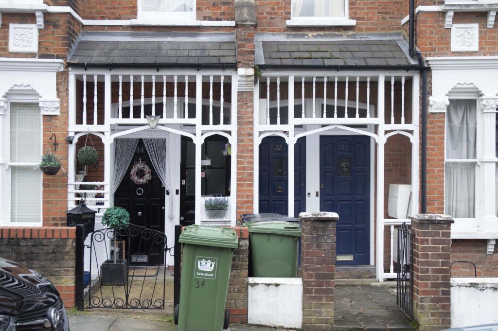 A photograph of two terraced houses with two front doors each.